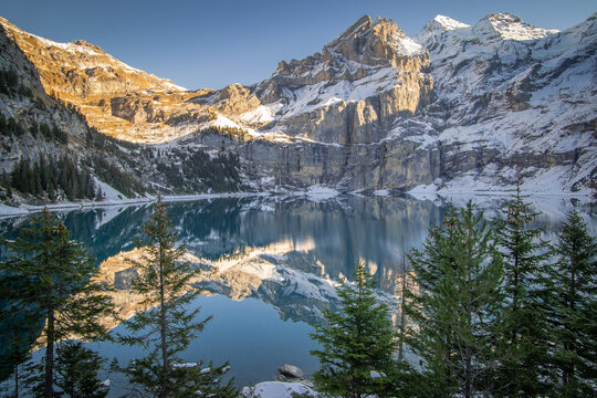 Dans les alpes suisses, photos d'un lac de montagnes avec la neige et des reflets.