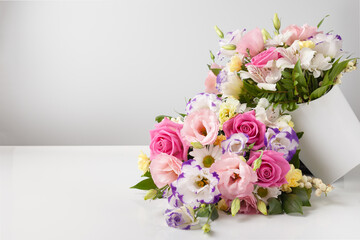 mock up two bouquets of different sizes of roses, daisies, lisianthus, chrysanthemums, unopened buds in a white paper box on a white background, one bouquet lies on top of the other.