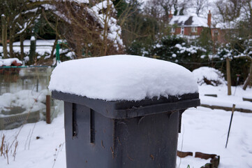 Thick snow on a wheelie bin lid