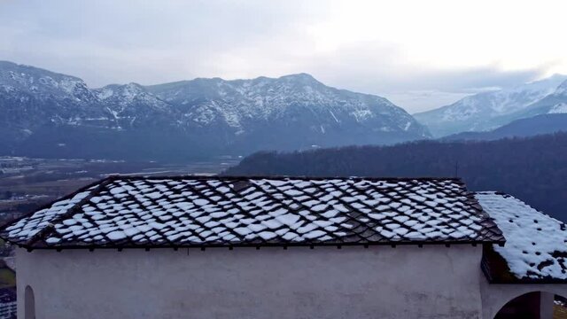 Drone 4K 30fps footage in Levico terme of the S. Biagio church, with frescoes dating back to the 13th &ndash; 16th centuries in Levico Terme, italy, trento, surrounded by the city, mountains and the lake. 