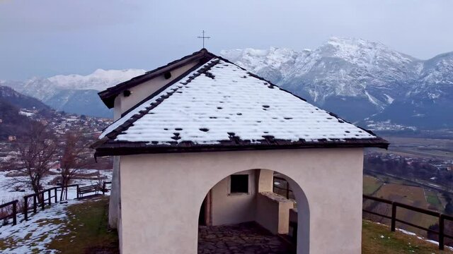 Drone 4K 30fps footage in Levico terme of the S. Biagio church, with frescoes dating back to the 13th &ndash; 16th centuries in Levico Terme, italy, trento, surrounded by the city, mountains and the lake. 