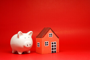 Fund , Investment , Saving money concept : Mockup White Piggy bank and House on red background with...