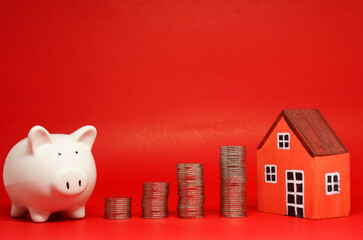 Fund , Investment , Saving money concept : White Piggy bank coin and House on red background with...