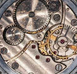 Vintage grunge background of an old clock. Abstract texture covered with dust, dirt, scratches. Macro photography in light tinted