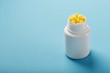 Vitamins are yellow in a white jar on a blue-blue background.