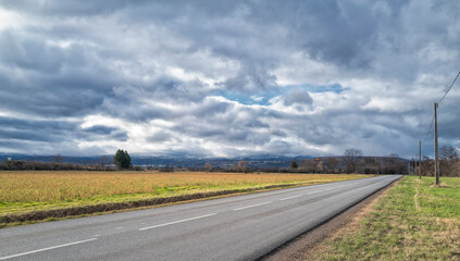 Fototapeta na wymiar route en Auvergne sous un ciel nuageux