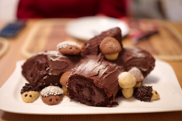 Decorated Christmas chocolate cake with cookies on white plate
