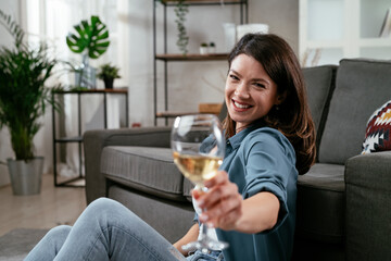 Beautiful woman drinking wine. Young woman enjoying at home and drinking wine.