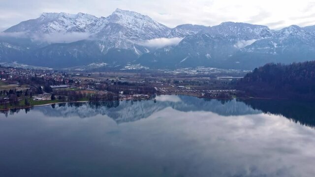 Drone aerial video footage above the Levico lake, facing the mountain Pizzo di Levico, with Forte Spitz Vezzena on the very top. Flying above the water
