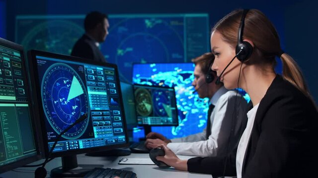 Workplace of the air traffic controllers in the control tower. Team of aircraft control officers works using radar, computer navigation and digital maps. Aviation concept.