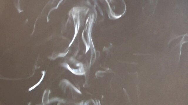 黒い背景に空中を漂うタバコの副流煙。喫煙、受動喫煙。