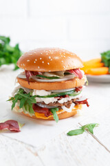 Fast food Burger. Close-up of tasty burger on a light wooden table and the background of a brick wall. Different type of sandwiches