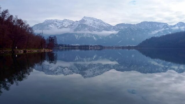Drone aerial video footage above the Levico lake, facing the mountain Pizzo di Levico, with Forte Spitz Vezzena on the very top. Flying above the water