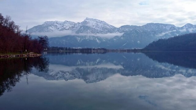 Drone aerial video footage above the Levico lake, facing the mountain Pizzo di Levico, with Forte Spitz Vezzena on the very top. Flying above the water