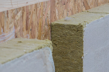 Visible rockwool or thermal insulation of a wooden house. Cut away profile of a wooden panel house insulation.