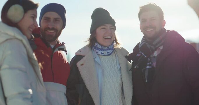 Diverse four amazing friends meeting together embracing each other sharing stories and communicating on beautiful sunny winter day.