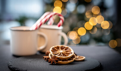 Dried lemon near mugs with christmas candies