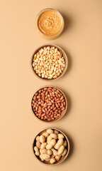 Bowls with tasty peanut butter and nuts on color background