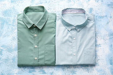 Folded male shirts on light background