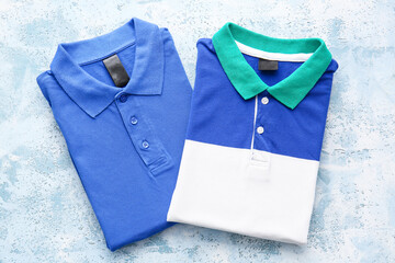 Folded polo shirts on light background