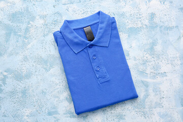 Folded polo shirt on light background