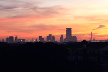 Naklejka na ściany i meble Orange morning sky sunrise over city skyscraper view, skyline horizon cityscape and urban architecture buildings at dawn
