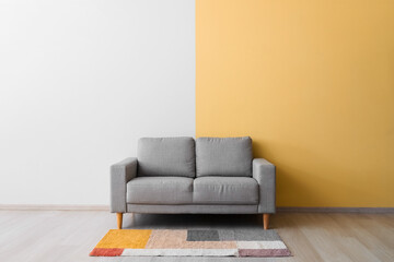 Stylish cozy sofa near color wall