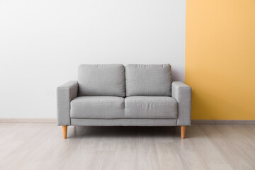 Stylish cozy sofa near color wall