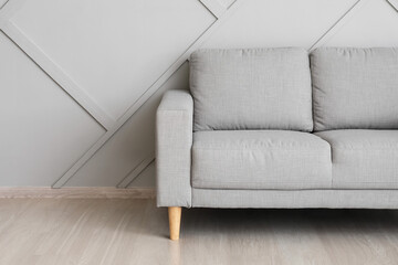 Stylish cozy sofa near light wall