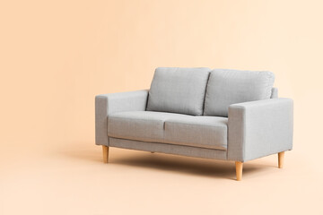 Stylish cozy sofa on color background