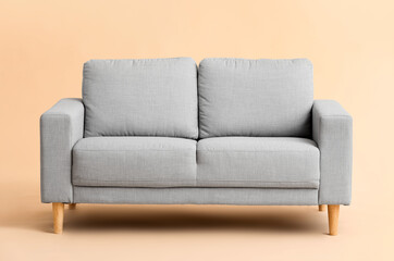 Stylish cozy sofa on color background