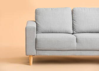 Stylish cozy sofa on color background