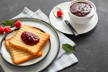Toasts with sweet raspberry jam on dark table