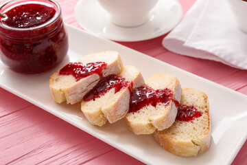 Bread with sweet raspberry jam on table
