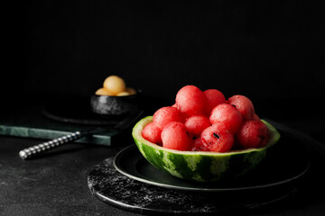 Tasty watermelon balls in ripe watermelon on dark background