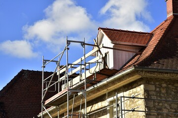 Gerüst an einem neu gebauten Haus im Rohbau in einem Neubaugebiet