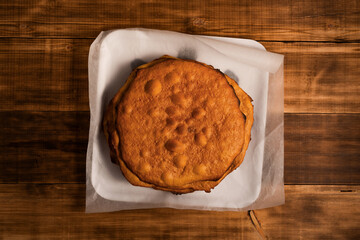 Empty cake crust on wooden rural kitchen table. Bakery thematic background.