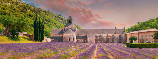 Notre-dame De Senanque Abbey, Vaucluse, France. Beautiful Landscape Lavender Field And An Ancient Monastery Abbaye Notre-dame De Senanque. Elevated View, Panorama. Altered Sunset Sky - obrazy, fototapety, plakaty