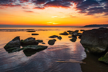 Fototapeta na wymiar Colorful sunrise on the rocky sea coast