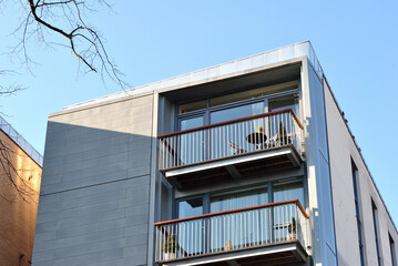 Balconies on Modern Apartment Building seen from Below against Blue Sky