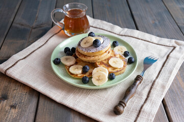 morning breakfast, pancakes with berries and bananas on a plate