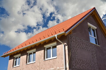 Neubau eines holzverschalten Niedrigenergie-Einfamilienhauses in Holzständer-Bauweise als Rohbau mit bereits angebrachtem Schneefanggitter