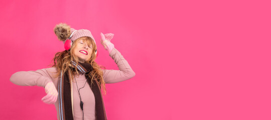 adult woman dancing with headphones and warm clothes isolated on background