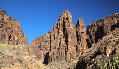 Fototapeta premium Gran Canaria, landscapes along the hiking route around the ravive Barranco Hondo, The Deep Ravine at the southern part of the island, full of caves and grottoes, close to small village Juan Grande