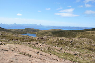 Beautiful scenic view over green hills, rocks and water  in Scotland