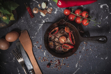 Cast-iron skillet: eggs, tomatoes and fried meat