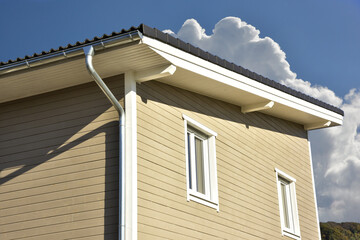 Neubau eines mit beschichteten Holzplanken verschalten Niedrigenergie-Einfamilienhauses in Holzständer-Bauweise mit immer häufiger verwendetem Pultdach mit Aufsparrendämmung