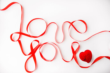 the inscription love you with a red ribbon on a white background and a red gift box in the shape of a heart for jewelry