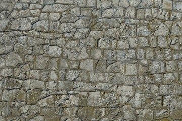 Natural stone wall made of rough stones and cement joints between