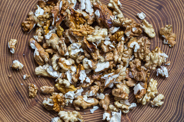 The freshly dehulled walnut kernel on wooden acacia tree slice top view 